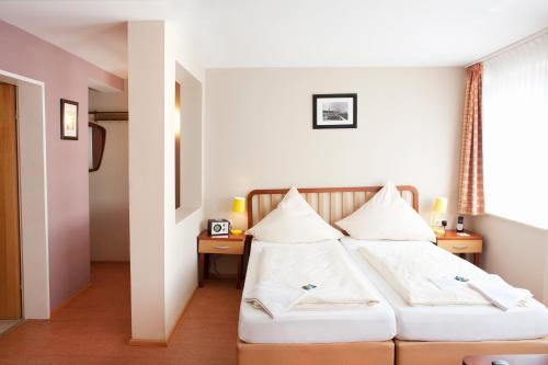 a bedroom with two beds with white pillows at Hotel Helgoländer Klassik in Helgoland