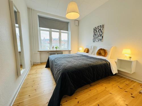 um quarto com uma cama grande e uma janela grande em aday - Randers cozy 1 bedroom apartment em Randers