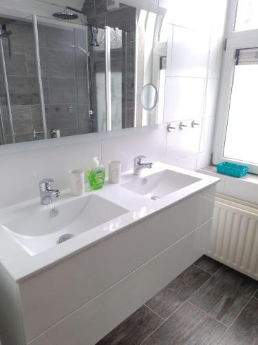 a white bathroom with a sink and a mirror at Villa-Meerchen-Villa-mit-ueberdachter-Terrasse-800m-vom-Strand-entfernt in Kamperland
