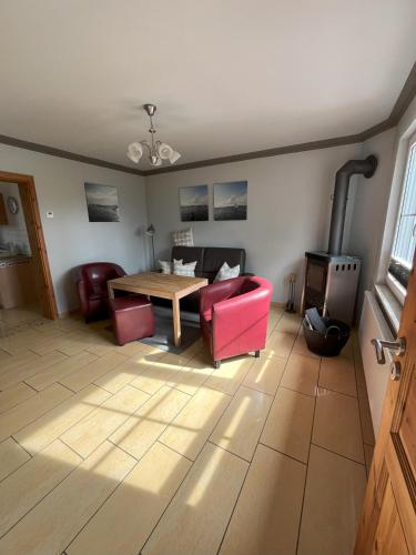 a living room with a table and red chairs at Küstenferienhaus Nr. 91/92 in Stahlbrode