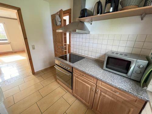 a kitchen with a stove and a microwave at Küstenferienhaus Nr. 91/92 in Stahlbrode