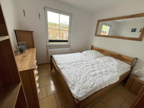a small bedroom with a bed and a mirror at Küstenferienhaus Nr. 91/92 in Stahlbrode