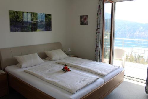 a bedroom with a large bed with a large window at Haus Franz in Millstatt
