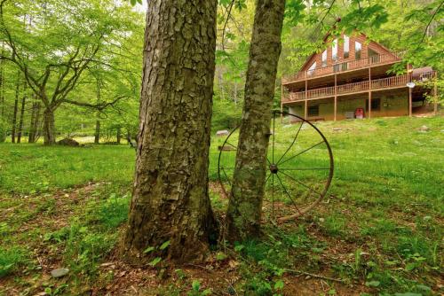 a farm house with a tractor in a field with trees at Hidden Creek Cabin in Fleetwood