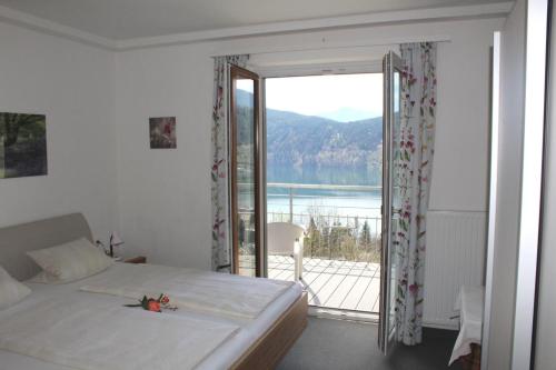 a bedroom with a bed and a balcony with a view at Haus Franz in Millstatt