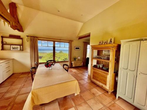 Zimmer mit einem Tisch und einem großen Fenster in der Unterkunft Le colombier, villa vue mer accès plage 300M in Varengeville-sur-Mer