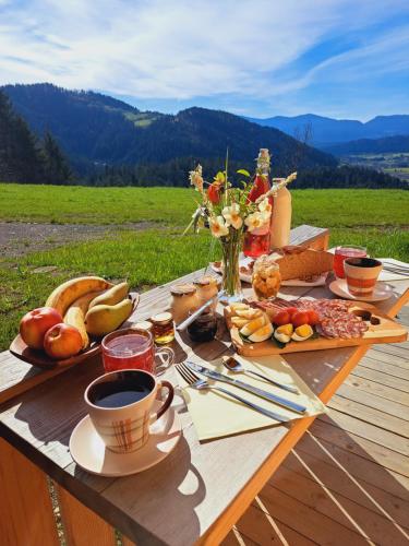 una mesa de picnic con comida y una taza de café en Glamping hiška Gril, en Ljubno