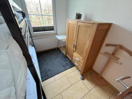 a bedroom with a bed and a wooden cabinet at Küstenferienhaus Nr. 91/92 in Stahlbrode