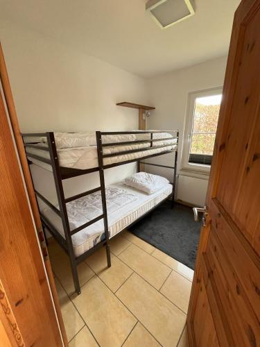 two bunk beds in a room with a window at Küstenferienhaus Nr. 91/92 in Stahlbrode