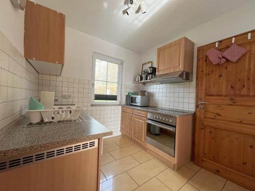 a kitchen with wooden cabinets and a counter top at Küstenferienhaus Nr. 91/92 in Stahlbrode