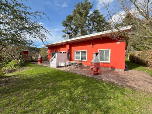 a red tiny house with a patio in a yard at Küstenferienhaus Nr. 91/92 in Stahlbrode