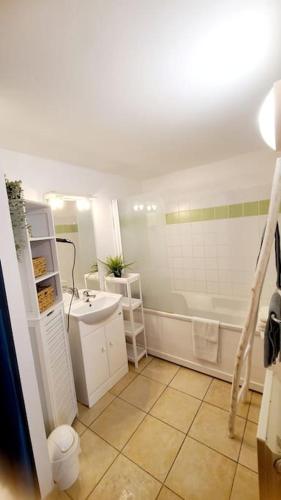une salle de bain avec une baignoire blanche et un lavabo dans l'établissement Le 114 - Appartement duplex terrasse piscine 6 pers, à Serra-di-Ferro