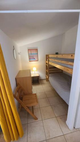 Cette petite chambre comprend des lits superposés et un banc. dans l'établissement Le 114 - Appartement duplex terrasse piscine 6 pers, à Serra-di-Ferro