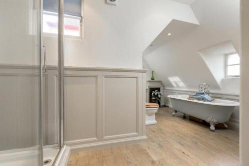 a white bathroom with a tub and a toilet at Flat on Ramsay in Edinburgh