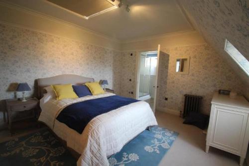 a bedroom with a bed with blue and yellow pillows at Flat on Ramsay in Edinburgh