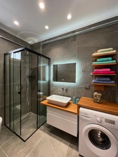 La salle de bains est pourvue d'un lave-linge et d'un lave-linge. dans l'établissement George Apartments, à Himarë