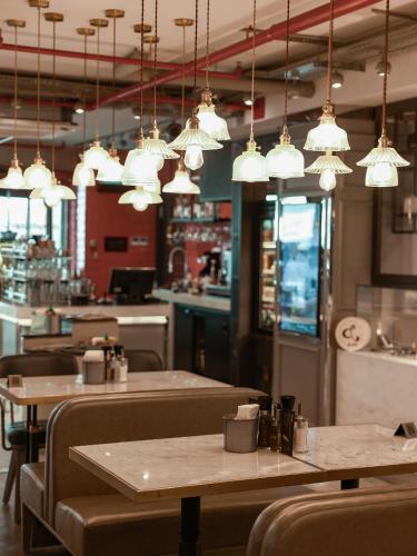 a restaurant with tables and chairs and pendant lights at Stayso The House Hotel in Istanbul