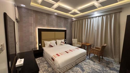 una camera da letto con un letto, un tavolo e una sedia di كنف أبها للشقق المخدومة a Abha