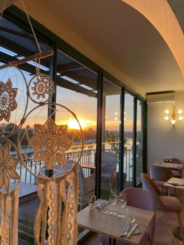 une salle à manger avec vue sur le coucher du soleil dans l'établissement CÔTE GARONNE le BALCON DES DAMES -hôtel et restaurant- Tonneins Fauillet Marmande - vue panoramique bord de Garonne chambres climatisées, à Tonneins