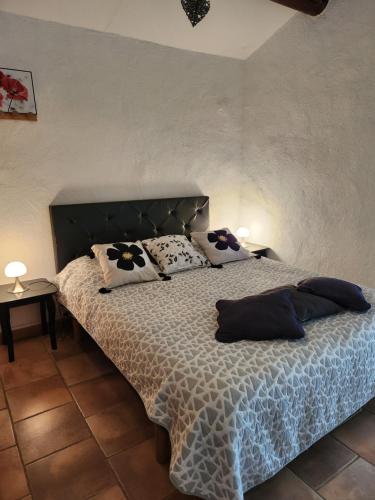 Un dormitorio con una cama con almohadas. en gîte Les Pégots - studio en Ménerbes