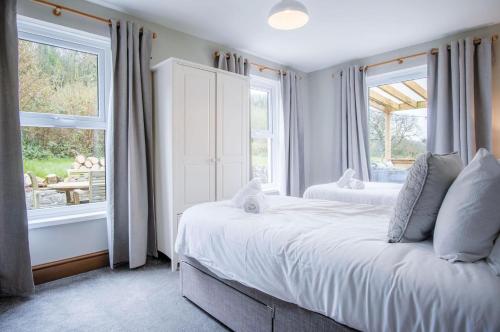 a bedroom with two beds and a window at Hill House - 4 Bedroom Holiday Home - Llanrhidian in Llanrhidian