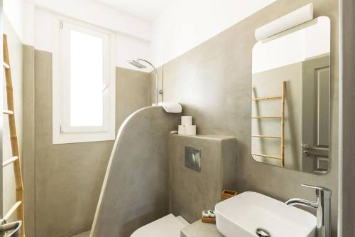 a bathroom with a sink and a toilet and a mirror at Luxury villa with private pool in Dhriopís