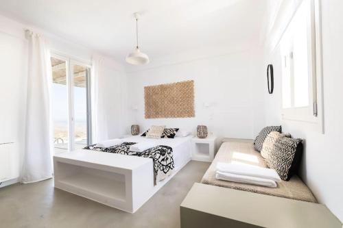 a white bedroom with a bed and a couch at Luxury villa with private pool in Dhriopís