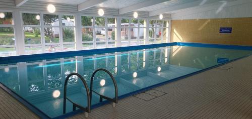 uma grande piscina com cadeiras em frente em KNAUS Campingpark Walkenried em Walkenried