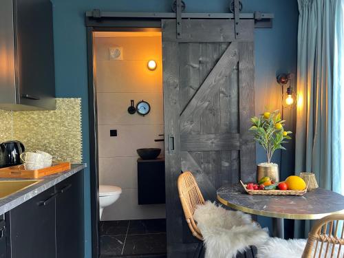 eine Küche mit einem Tisch und einer Scheunentür in der Unterkunft B&B/Tiny House Bij Zee in Stellendam