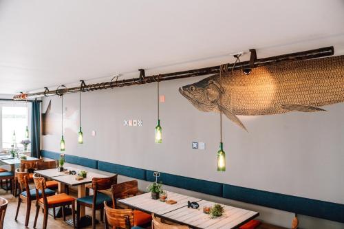 a restaurant with tables and a fish on the wall at Inselresort Wilhelmstein in Steinhude
