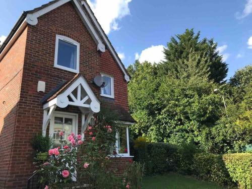 a red brick house with flowers in the front yard at Comfortable. home from home in Loudwater