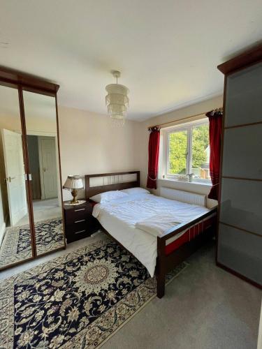 1 dormitorio con cama y ventana grande en Comfortable. home from home en Loudwater