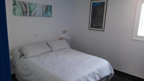 een klein bed in een witte kamer met: bij Apartbeach Marina in Candelaria