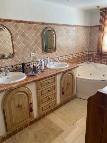 La salle de bains est pourvue de 2 lavabos, d'une baignoire et d'une baignoire. dans l'établissement Villa Goonie, aux Issambres
