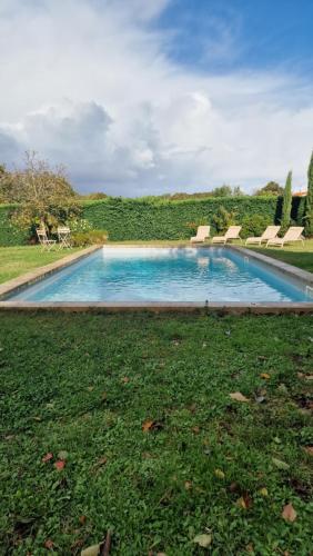 a swimming pool in the middle of a grass field at Casita Alegria & Cabana Alegria - 2 chambres d'hôtes in Plassac
