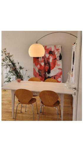 a dining room table with two chairs and a painting at Room in Marzili in Bern