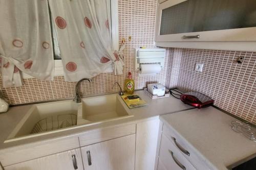 a kitchen counter with a sink and a window at Βίλα Χαρά in Eretria