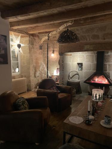 a living room with leather furniture and a fireplace at Gîte de charme avec spa sous les étoiles Corrèze in La Roche-Canillac