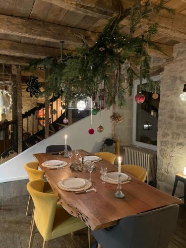 a dining room with a wooden table and yellow chairs at Gîte de charme avec spa sous les étoiles Corrèze in La Roche-Canillac