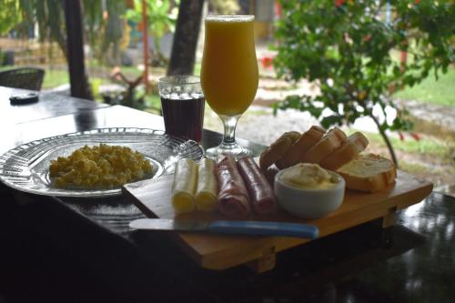 una mesa con una bandeja de comida y un vaso de cerveza en Solar Hostel Búzios, en Búzios