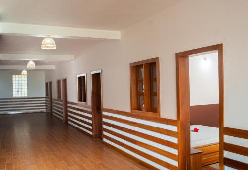 HOROKO HOTEL في نوسي بي: غرفة بها صف من الأبواب والأرضيات الخشبية