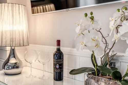 a bottle of wine sitting on a table with two glasses at Rome55 - Piazza di Spagna in Rome