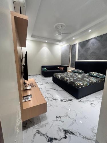 阿姆利则Wonderstays的一间卧室，配有一张床和一张带电视的书桌