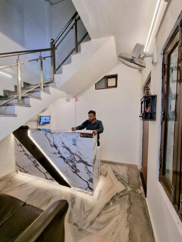 a man standing on a ramp in a room with stairs at Hotel Sangam View in Prayagraj