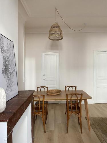 une salle à manger avec une table et des chaises en bois dans l'établissement Cozy flat fully renovated by interior designer, à Marseille