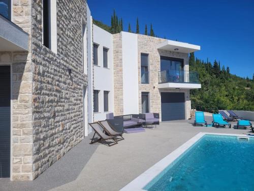 a house with a swimming pool next to a building at Bay View Village - Villa Eléanore 2 in Herceg-Novi