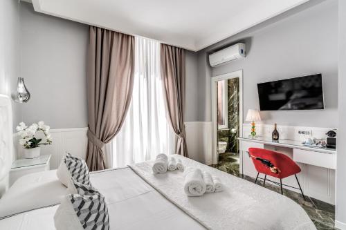 biały pokój z łóżkiem i czerwonym krzesłem w obiekcie Rome55 - Piazza di Spagna w Rzymie