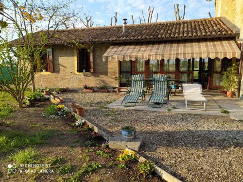 uma casa com duas cadeiras e um alpendre em La Rosa Selvatica em Ravarino