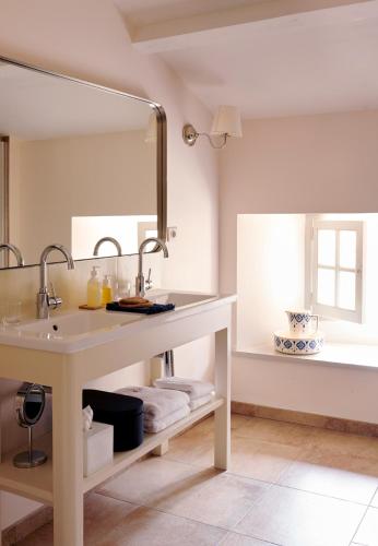 une salle de bain avec un lavabo et un miroir dans l'établissement Villa de La Roussie, à Saint-Sulpice-de-Mareuil