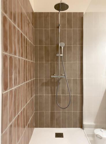 une douche avec pommeau de douche dans une salle de bain dans l'établissement Cozy flat fully renovated by interior designer, à Marseille